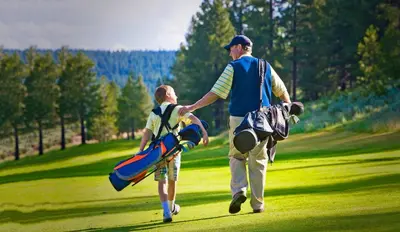 a man and a boy walking on a golf course at 4081 Ski Trails in Truckee