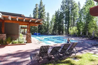 a pool with chairs and a person sitting in front of it at 3132 Aspen Grove in Truckee