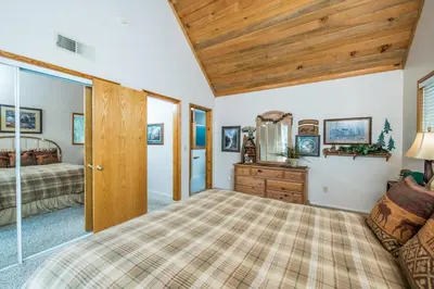 a bedroom with a bed and a wooden ceiling at Sparrow Cove in Shaver Lake