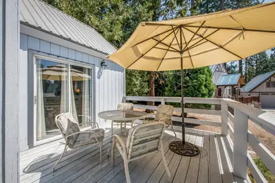 a patio with a table and chairs and an umbrella at Sparrow Cove in Shaver Lake