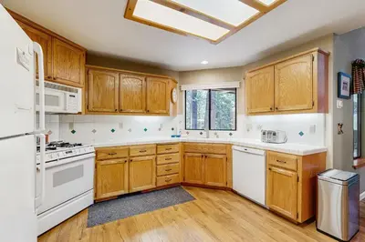 a kitchen with wooden cabinets and white appliances at The Rockin' Buffalo in Shaver Lake