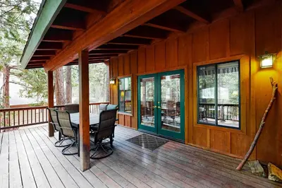 a porch of a house with a table and chairs at The Rockin' Buffalo in Shaver Lake