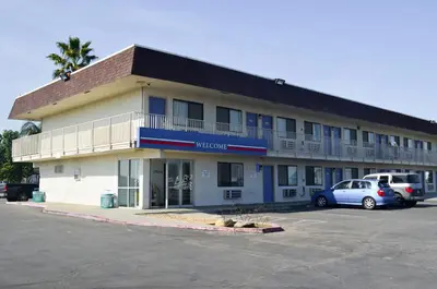 a hotel with a car parked in a parking lot at Motel 6 Lost Hills / Buttonwillow Racetrack in Lost Hills