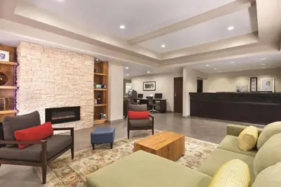 a living room with a couch and chairs and a fireplace at Country Inn & Suites by Radisson, Fresno North, CA in Fresno