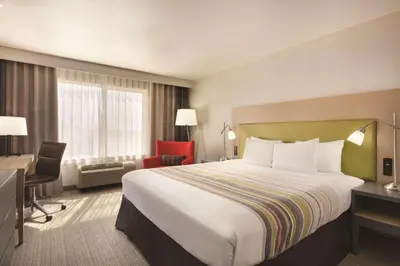 a hotel room with a large bed and a desk at Country Inn & Suites by Radisson, Fresno North, CA in Fresno