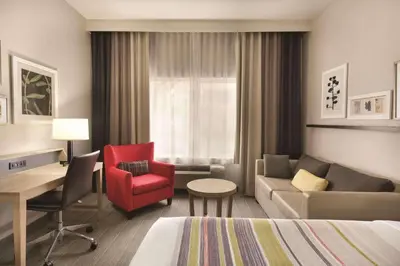 a hotel room with a bed and a couch and a desk at Country Inn & Suites by Radisson, Fresno North, CA in Fresno