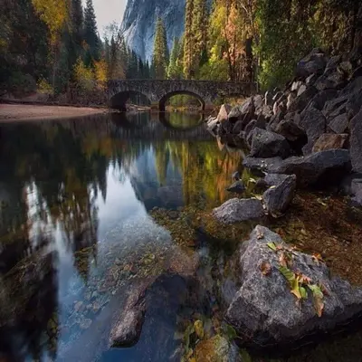 a bridge over a body of water with rocks at Yosemite Foothill Retreat in Coarsegold