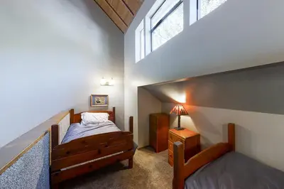 a bedroom with a wooden bed and a window at Eagles Nest Condo #88 in Lakeshore