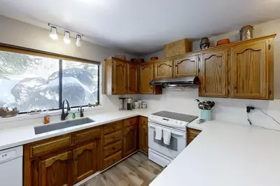 a kitchen with wooden cabinets and a sink and a window at Eagles Nest Condo #88 in Lakeshore