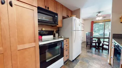 a kitchen with wooden cabinets and a white refrigerator at Snowcreek 247 Townhouse in Mammoth Lakes