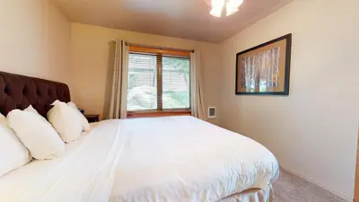 a bedroom with a white bed and a window at Snowcreek 247 Townhouse in Mammoth Lakes