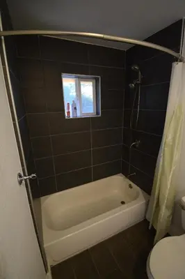 a bathroom with a tub and a toilet and a window at Mountain Place in Groveland