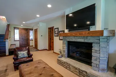 a living room with a fireplace and a flat screen tv at Gray Stone Condo #2110 in Mammoth Lakes