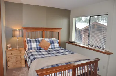 a bedroom with a bed with a wooden headboard and a window at Bitterbrush - 400 Fairview Boulevard - very close to Diamond Peak and beaches - WSTR21-0086 - Tax ID W4900 - Max 7 people, 2 cars parking in carports in Incline Village