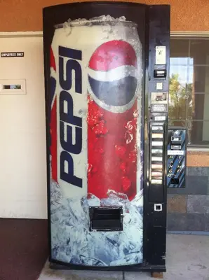 a vending machine with a soda bottle painted on it at Village Inn in Tulare