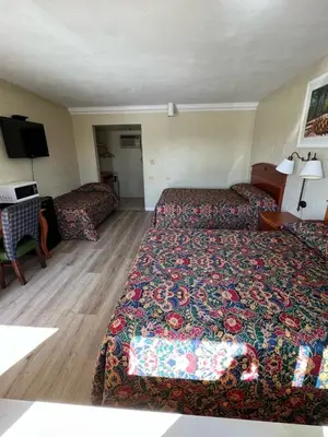 a hotel room with a bed and a couch at Village Inn in Tulare