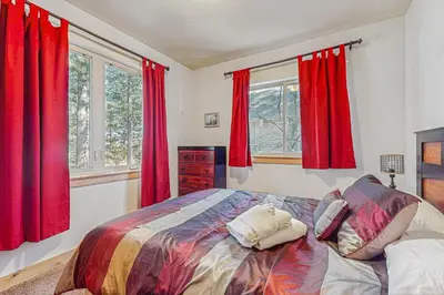a bedroom with red curtains and a large bed at Elegant Pine in South Lake Tahoe