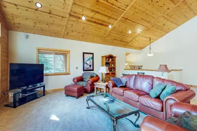 a living room with a leather couch and a flat screen tv at Brookstone Haven in Truckee