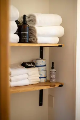 a shelf with towels and toiletries in a bathroom at Lake Front Cabins in June Lake