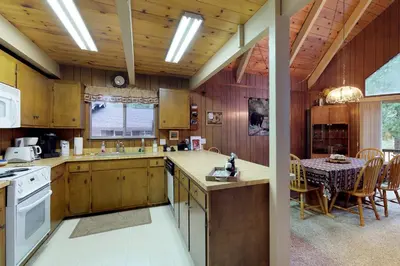 a kitchen with wooden cabinets and a table and a dining room at Bears Meadow in Arnold