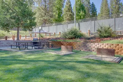 a park with two picnic tables in the grass at Cypress Lodge in Arnold