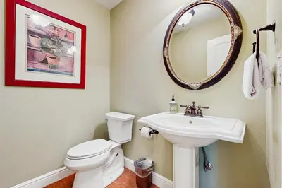 a bathroom with a white toilet and a sink at Cypress Lodge in Arnold
