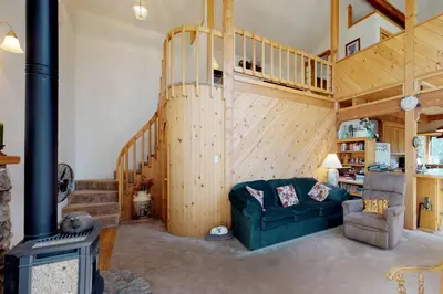 a living room with a green couch and a wood stove at The Davis Classic in Arnold