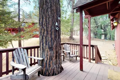 two chairs sitting next to a tree on a porch at Forest Bears Hideout in Arnold