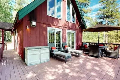 a red house with chairs and tables on a deck at Forest Bears Hideout in Arnold