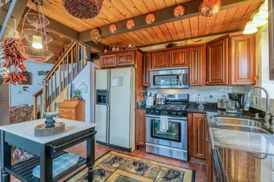 a kitchen with wooden cabinets and a sink at Forest Bears Hideout in Arnold