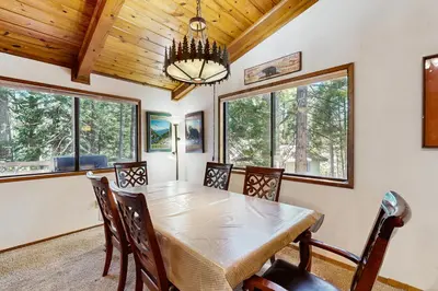 a dining room with a table and chairs and windows at On The 9th in Arnold