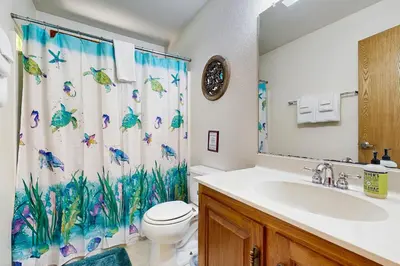 a bathroom with a sink and a toilet and a shower curtain at On The 9th in Arnold
