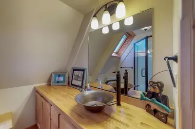 a bathroom with a sink and a large mirror at Stiles Mountain Hideaway in Arnold