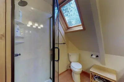 a bathroom with a toilet and a shower with a window at Stiles Mountain Hideaway in Arnold