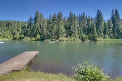 a dock on a lake with trees in the background at Stiles Mountain Hideaway in Arnold