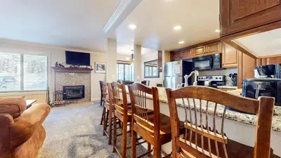 a kitchen with a group of chairs in a room at Horizons 4 #165 Condo in Mammoth Lakes