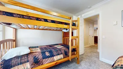 a bedroom with two bunk beds and a hallway at Horizons 4 #165 Condo in Mammoth Lakes