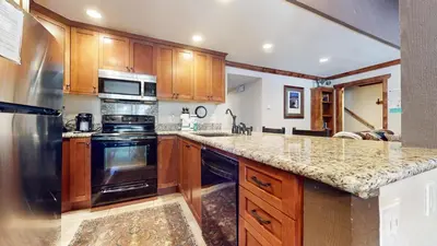 a kitchen with wooden cabinets and a granite counter top at Horizons Condo 4 #166 in Mammoth Lakes