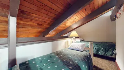 a attic bedroom with a bed and a wooden ceiling at Horizons Condo 4 #166 in Mammoth Lakes
