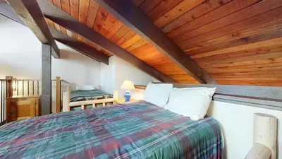a bedroom with a bed and a wooden ceiling at Horizons Condo 4 #166 in Mammoth Lakes
