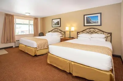 a hotel room with two beds and a window at Travelodge by Wyndham Hawthorne in Hawthorne