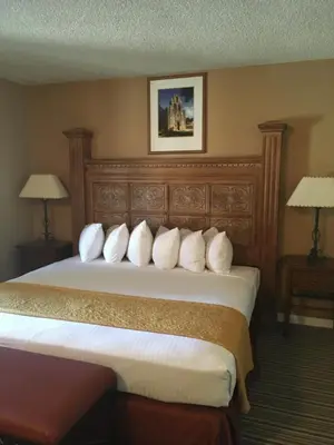 a hotel room with a bed with white pillows at Travelodge by Wyndham Hawthorne in Hawthorne
