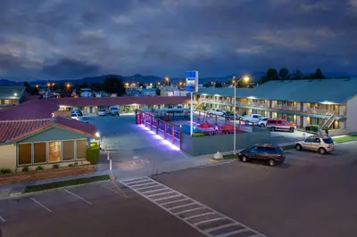 a parking lot in front of a hotel at night at Travelodge by Wyndham Hawthorne in Hawthorne