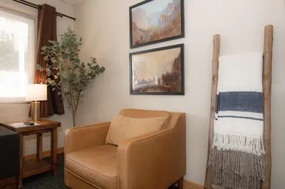 a living room with a chair and a painting on the wall at Gull Lake Lodge in June Lake