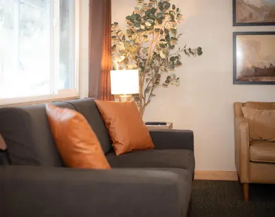 a living room with a gray couch with orange pillows at Gull Lake Lodge in June Lake