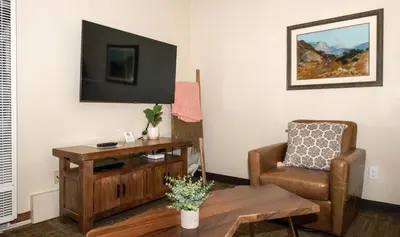 a living room with a chair and a television at Gull Lake Lodge in June Lake
