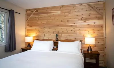a bedroom with a wooden accent wall and a bed at Gull Lake Lodge in June Lake