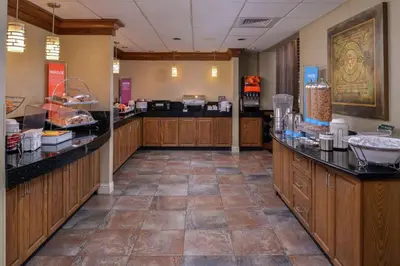 a kitchen with wooden cabinets and black counter tops at Hampton Inn & Suites Carson City in Carson City
