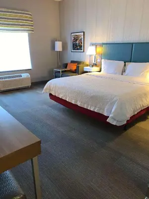 a bedroom with a large bed and a living room at Hampton Inn & Suites Carson City in Carson City