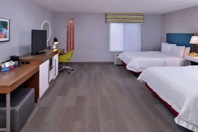 a hotel room with two beds and a desk with a television at Hampton Inn & Suites Carson City in Carson City
